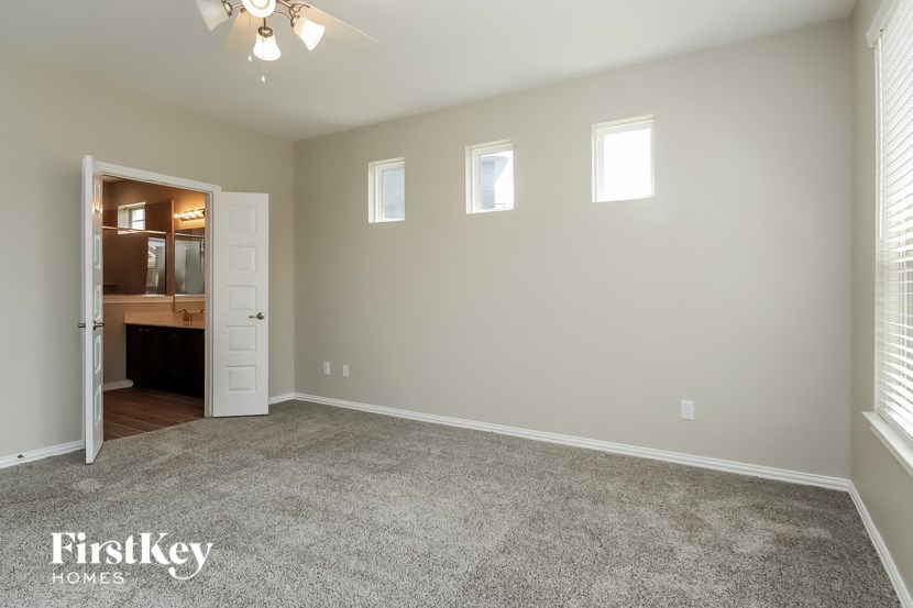 a living room with a carpeted floor and a door to a kitchen