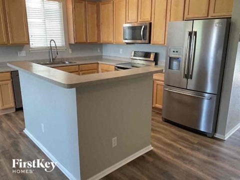 A kitchen with wooden cabinets and a stainless steel refrigerator.