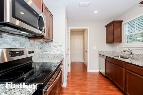 A kitchen with a stove top oven and microwave above it.