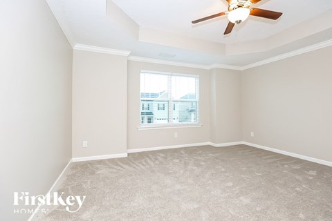 A spacious room with a ceiling fan and a window.