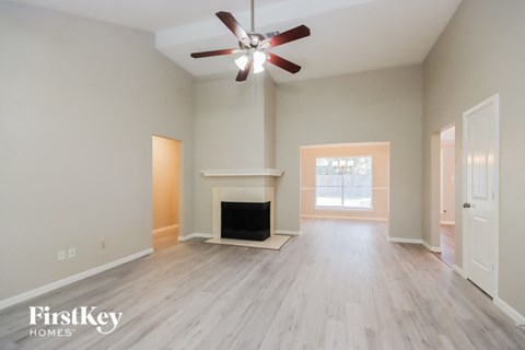 a living room with a fireplace and a ceiling fan