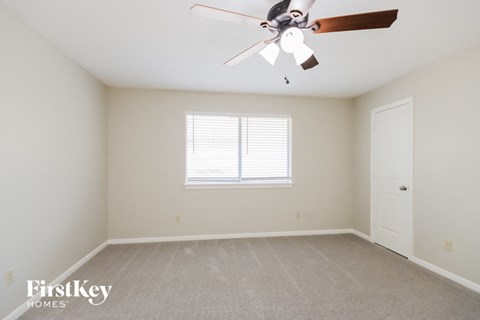 a bedroom with a ceiling fan and a window