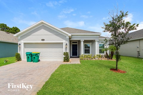 a white house with a lawn and a driveway