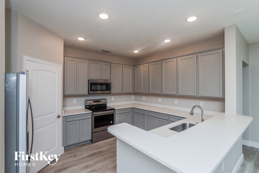 a kitchen with white counter tops and gray cabinets
