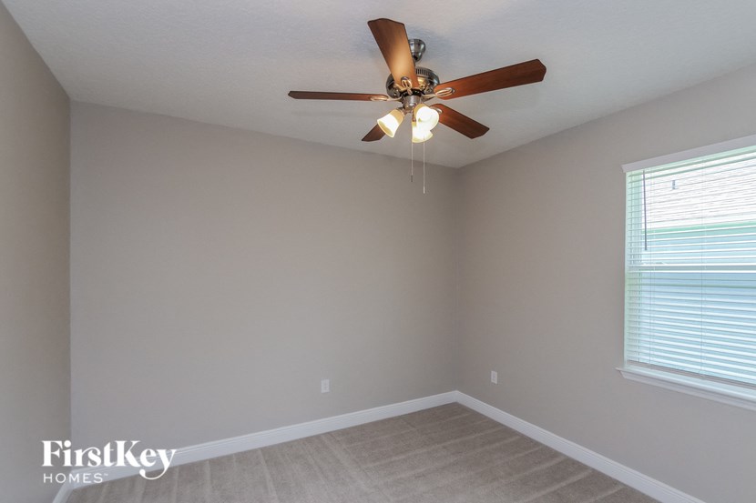 a bedroom with a ceiling fan and a window
