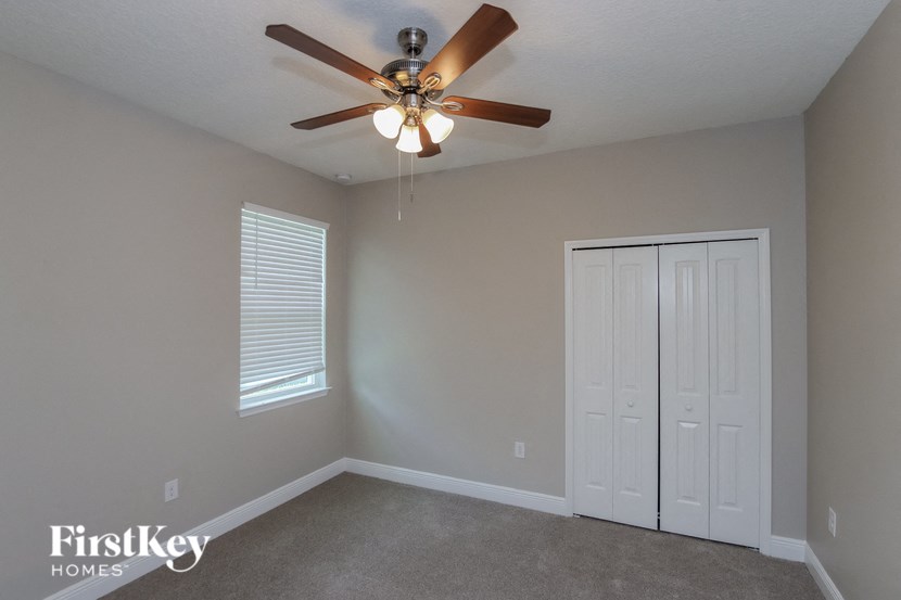 a bedroom with a ceiling fan and a closet