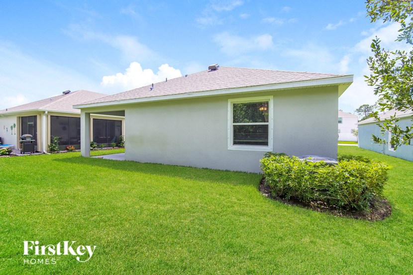 a white house with a yard and a green lawn