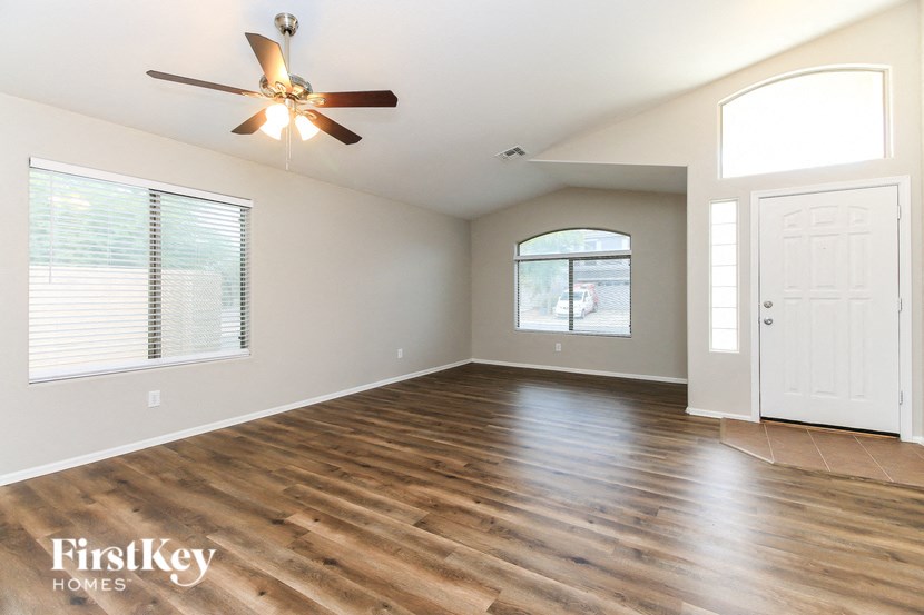 A room with a ceiling fan and wooden flooring.