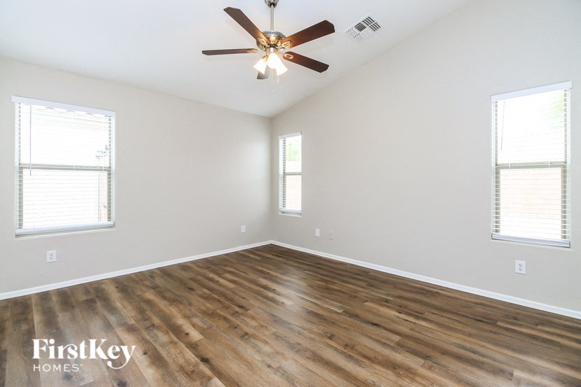 A room with a ceiling fan and wooden flooring.