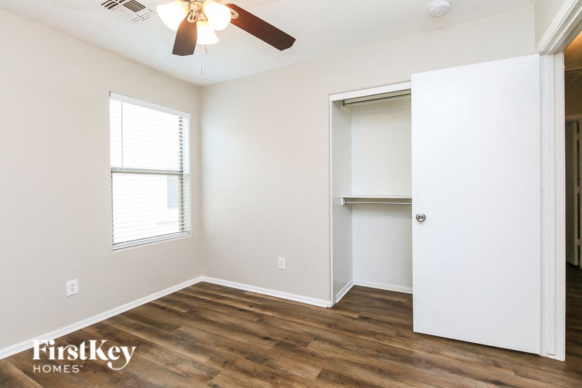 A room with a ceiling fan and a window.