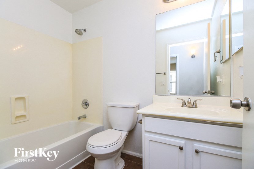 A white bathroom with a toilet, sink and bathtub.