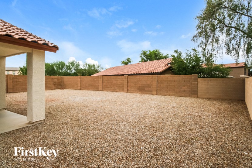 A backyard with a brown fence and a small building.