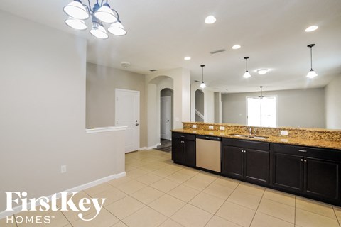 a large kitchen with granite counter tops and dark cabinets