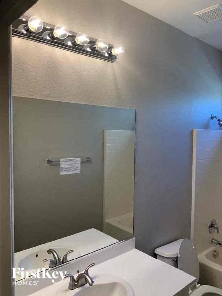 a bathroom with a mirror and a sink and a toilet