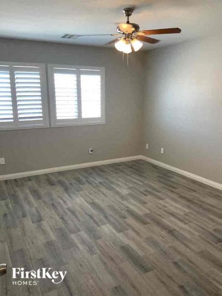 a empty room with a ceiling fan and a window
