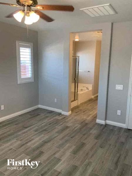 an empty room with a ceiling fan and a bathroom