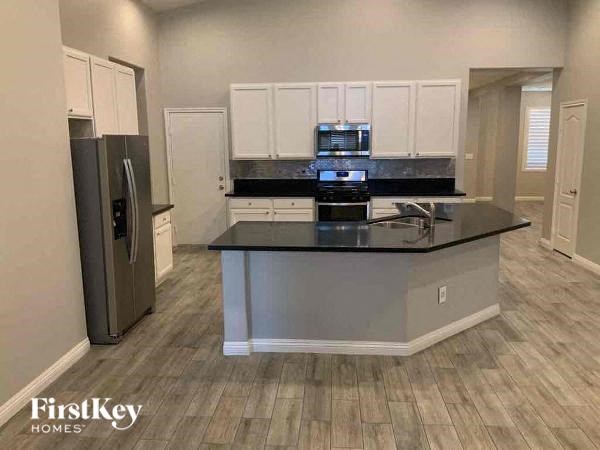 a kitchen with a black counter top and a refrigerator