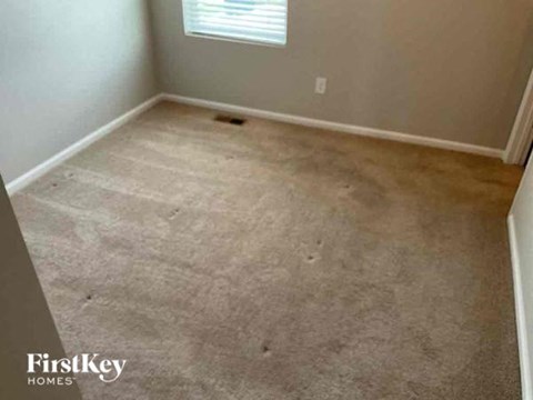 an empty room with a carpeted floor and a window