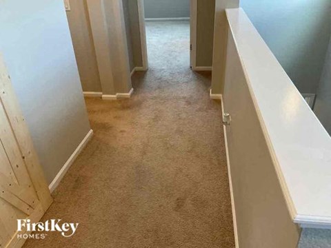 a hallway with white walls and a carpeted floor