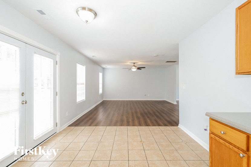an empty kitchen and living room with wood floors and white walls