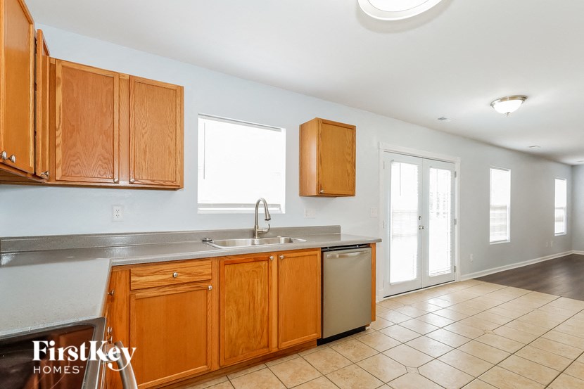a kitchen with wooden cabinets and stainless steel appliances and a sink
