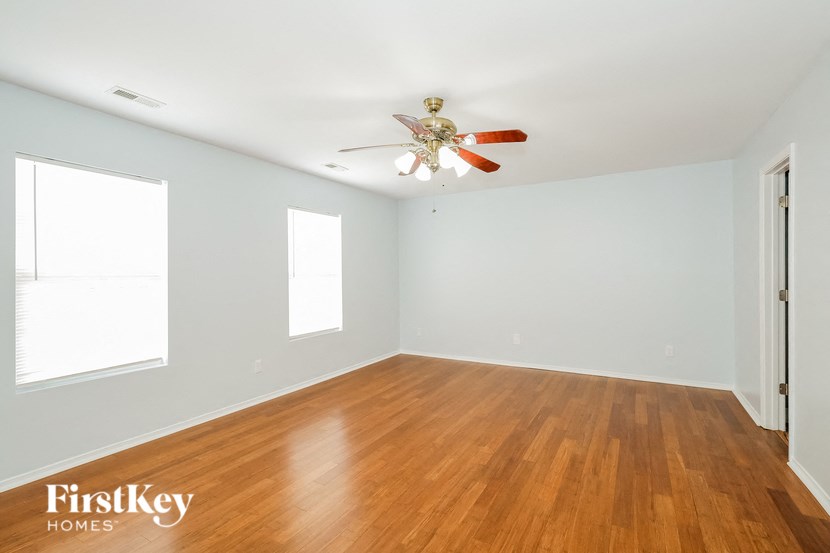a living room with wood floors and a ceiling fan