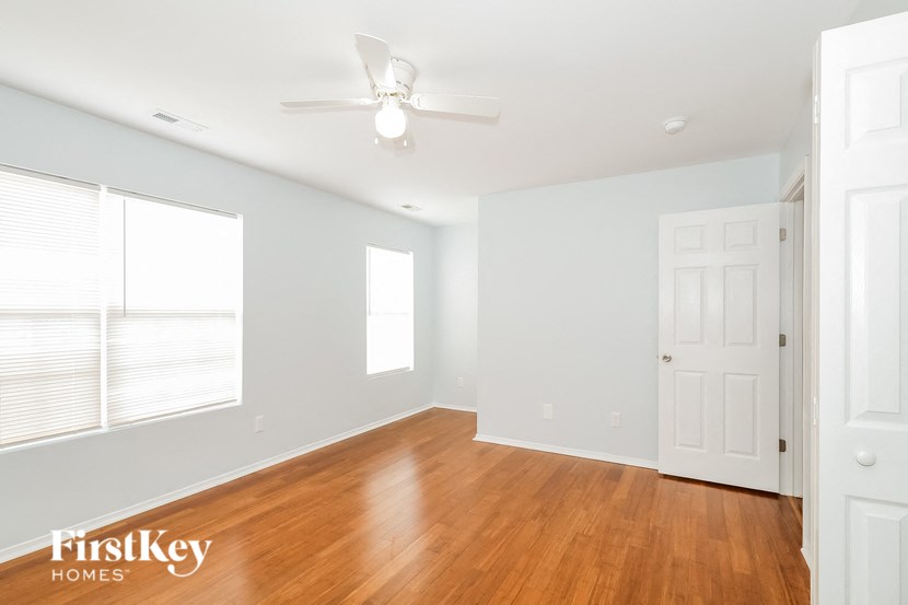 a living room with wood flooring and a ceiling fan