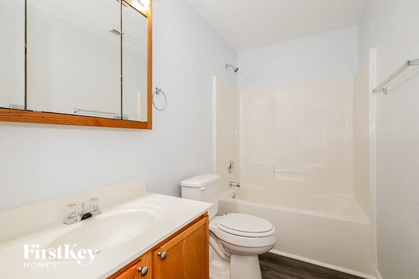a bathroom with a sink toilet and shower and a mirror
