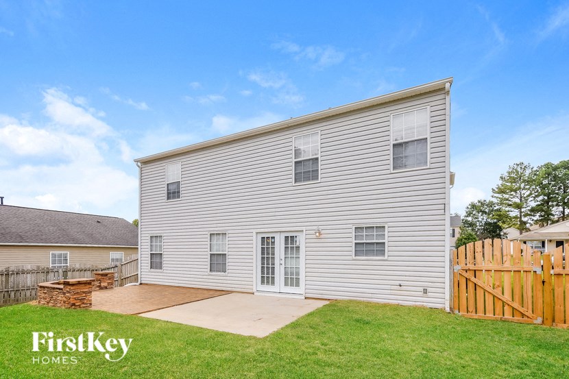 a white house with a backyard and a wooden fence
