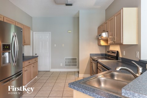 A kitchen with a stainless steel refrigerator and a sink.