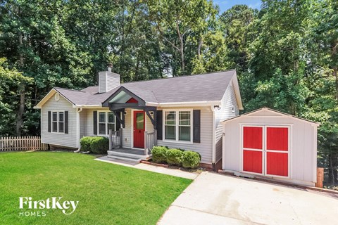 a small house with a red garage door and a lawn