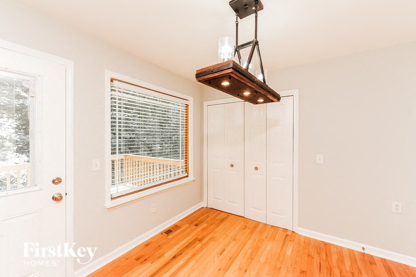 a living room with wood floors and a large window and a closet