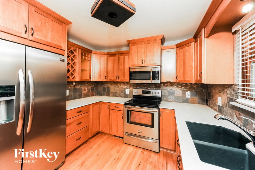 a kitchen with wooden cabinets and stainless steel appliances