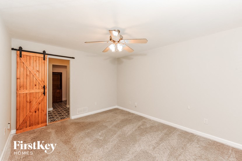a living room with a ceiling fan and a closet