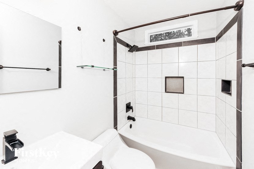a white bathroom with a tub and a sink