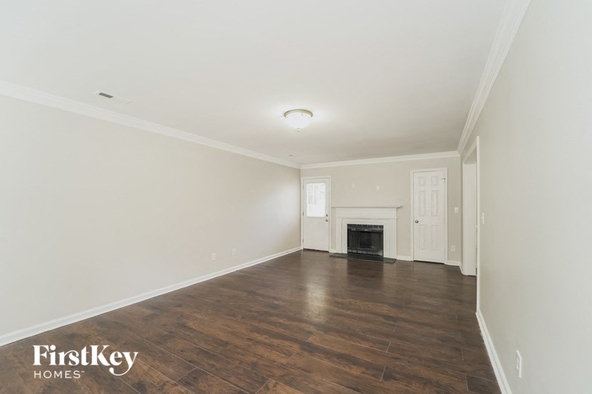 an empty living room with white walls and a fireplace