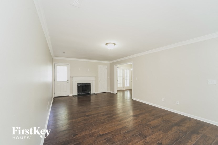 an empty living room with white walls and a fireplace