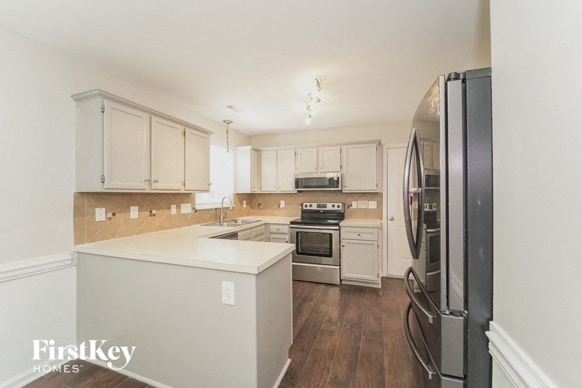 a kitchen with white cabinets and stainless steel appliances