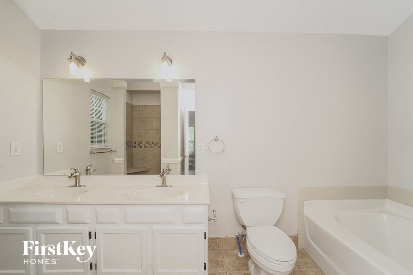 a white bathroom with a toilet and a sink and a tub