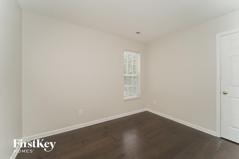 the living room of a home with wood floors and white walls