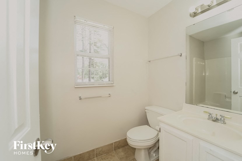 a bathroom with a toilet and a sink and a mirror