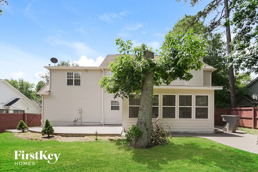 a white house with a tree in the yard