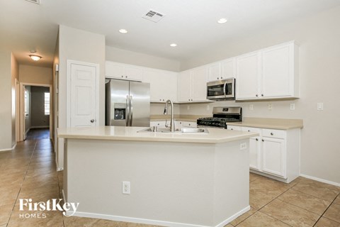 A kitchen with white cabinets and appliances in a house.
