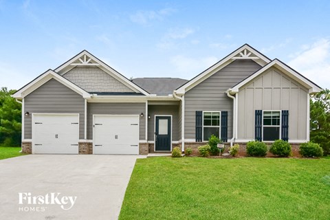 a house with two garage doors and a lawn