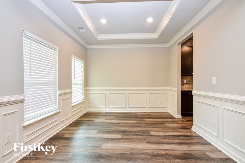 a dining room with wood floors and white walls