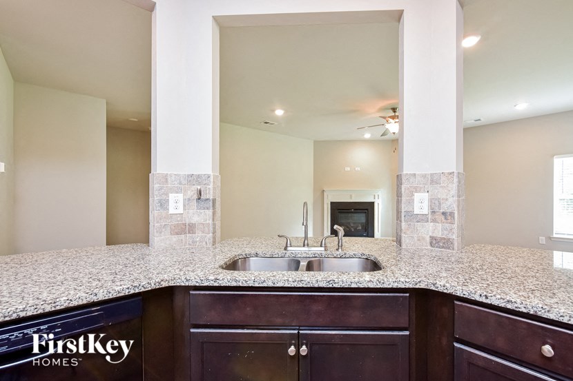 the kitchen has granite counter tops and a stainless steel sink