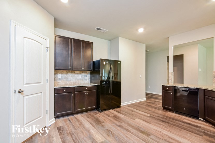 a kitchen with dark cabinets and a black refrigerator
