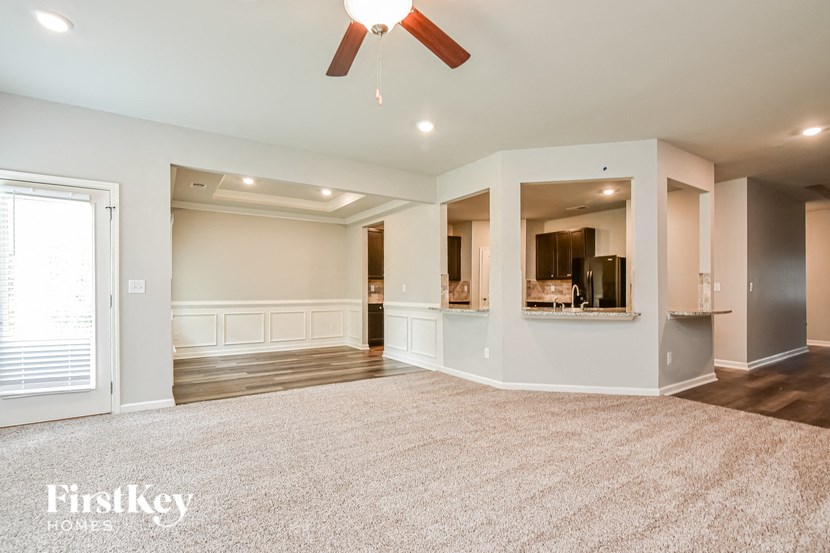 an empty living room with a ceiling fan