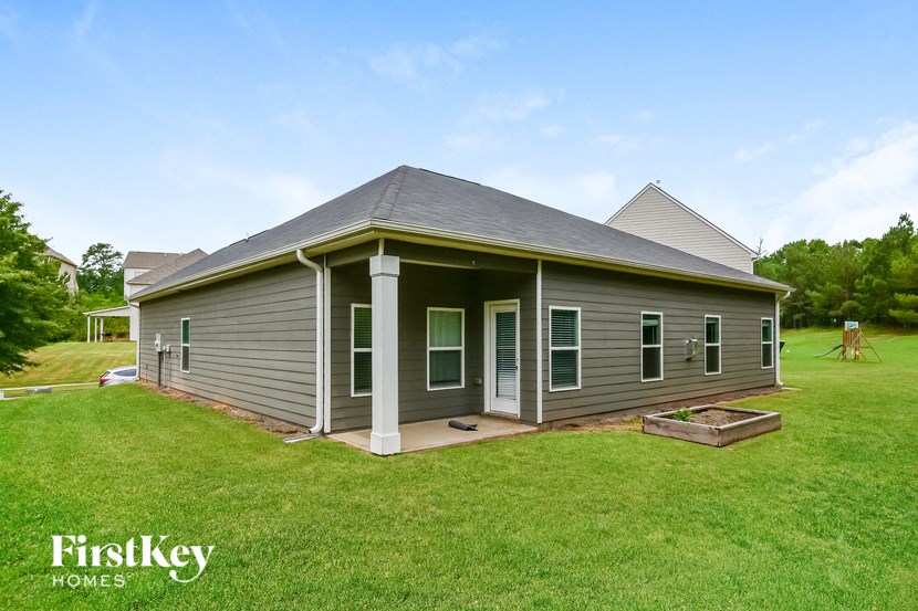 a gray house with a porch and a grassy yard