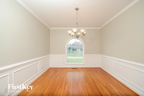 a dining room with a large window and wooden floors